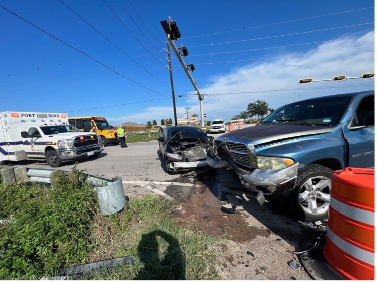 A damaged truck on the roadside after a collision, with debris scattered around and emergency responders present.